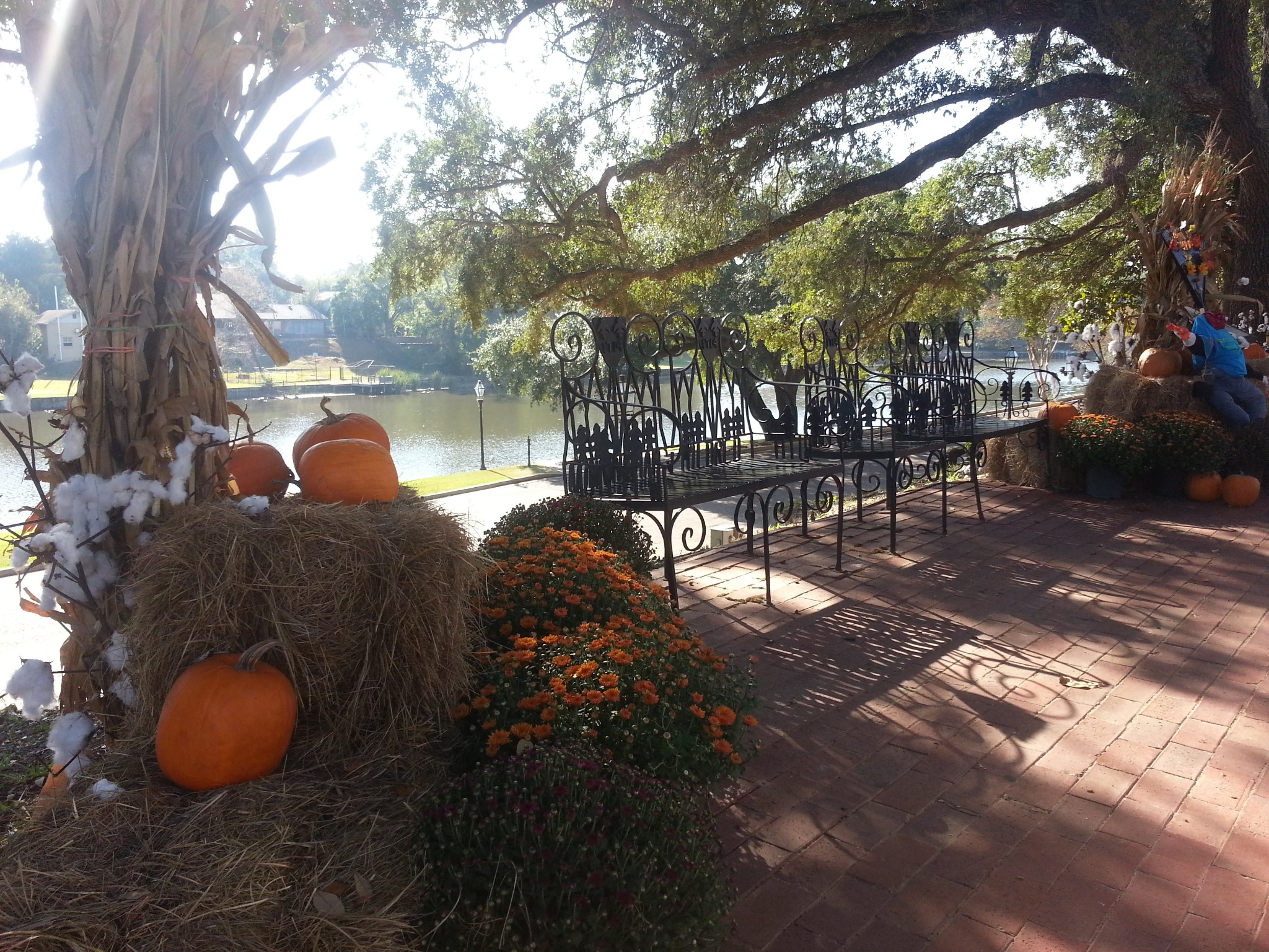 Pumpkins, fall flowers, and wrought-iron seating overlooking Cane River Lake